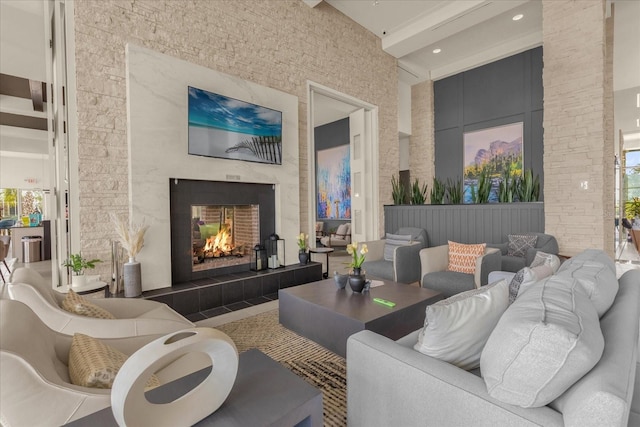 living room featuring a tiled fireplace and a high ceiling