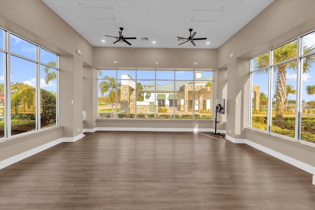 unfurnished sunroom with ceiling fan and a healthy amount of sunlight