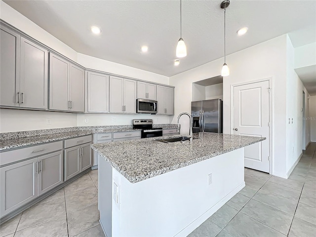 kitchen featuring gray cabinetry, appliances with stainless steel finishes, sink, and an island with sink