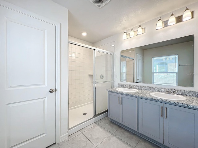 bathroom with vanity, a shower with shower door, and tile patterned flooring