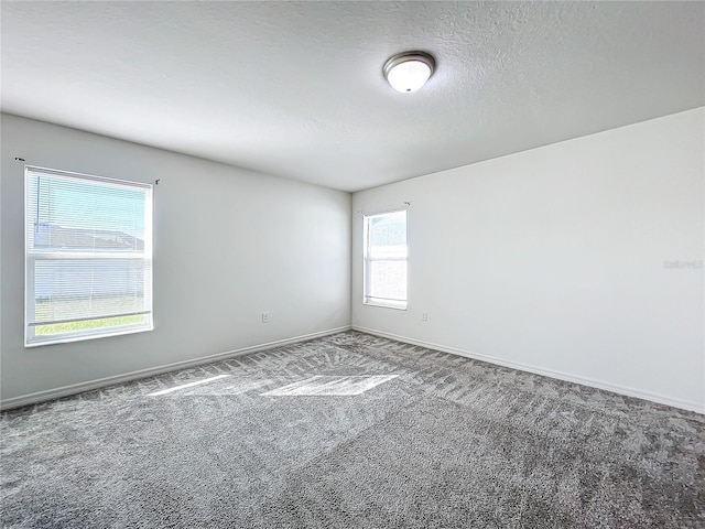 carpeted spare room with a textured ceiling