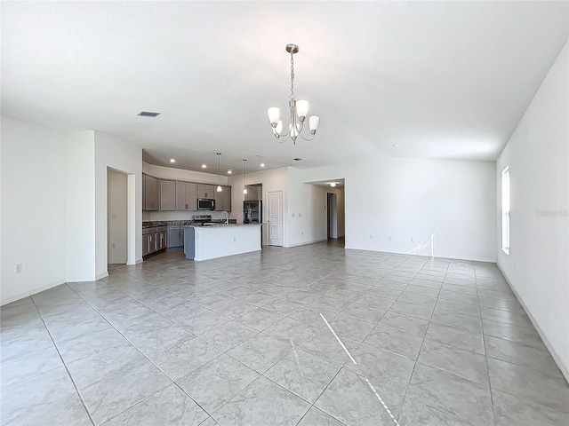 unfurnished living room with light tile patterned flooring and a chandelier