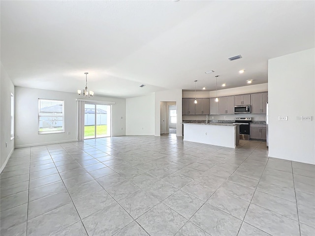 unfurnished living room featuring a notable chandelier and light tile patterned floors