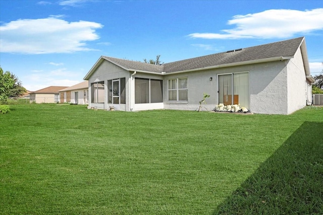 rear view of property featuring a sunroom, a yard, and central AC