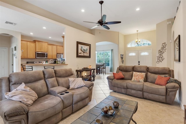 tiled living room featuring ceiling fan with notable chandelier