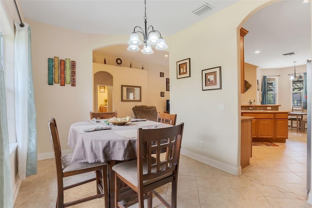 tiled dining space with an inviting chandelier and sink