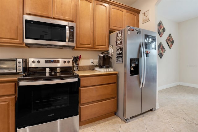 kitchen featuring appliances with stainless steel finishes and light tile patterned flooring