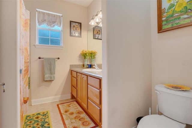 bathroom with toilet, vanity, and tile patterned floors