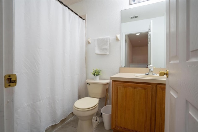 bathroom with tile patterned flooring, vanity, and toilet