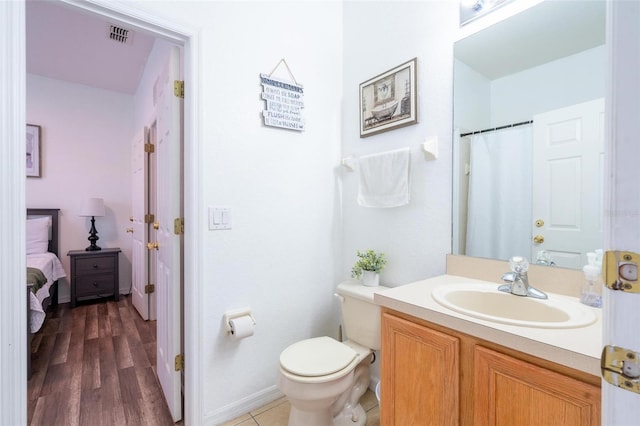 bathroom featuring hardwood / wood-style floors, vanity, and toilet