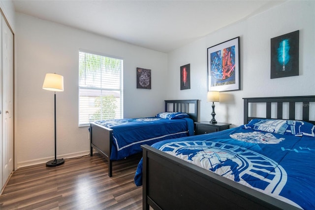 bedroom with dark hardwood / wood-style floors and a closet