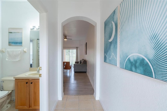 corridor featuring sink and light hardwood / wood-style flooring