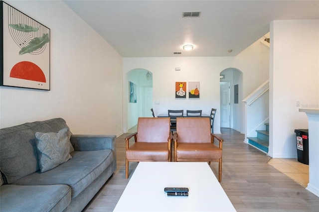 living room with electric panel and light hardwood / wood-style flooring