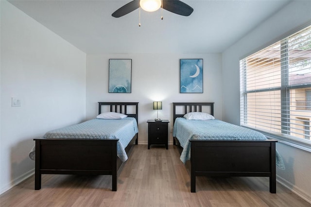 bedroom featuring multiple windows, ceiling fan, and hardwood / wood-style floors