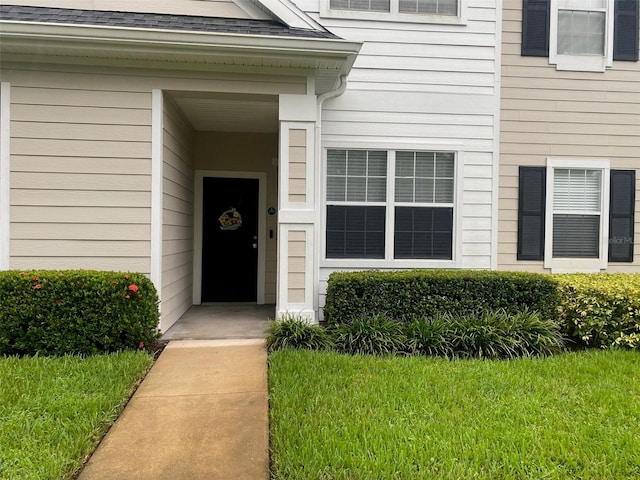 view of exterior entry with a lawn