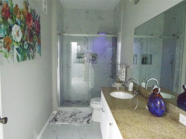 bathroom with vanity, toilet, and a shower with door