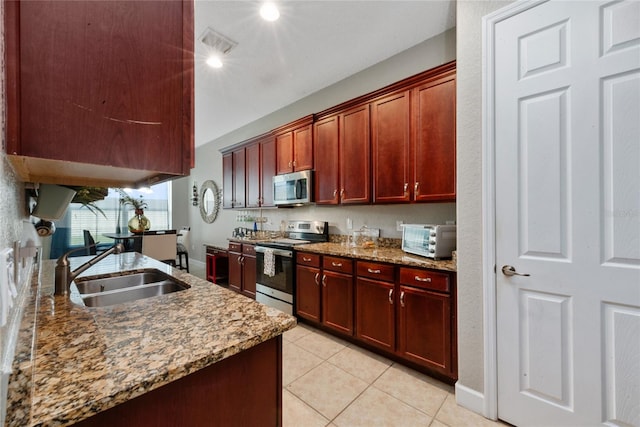 kitchen featuring sink, appliances with stainless steel finishes, light stone counters, and light tile patterned floors