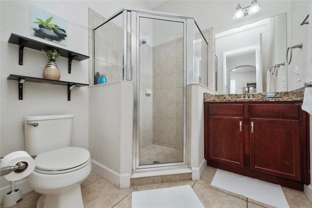 bathroom featuring a shower with door, vanity, toilet, and tile patterned flooring