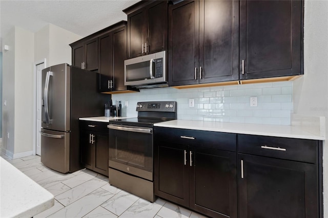 kitchen with appliances with stainless steel finishes, dark brown cabinetry, a textured ceiling, and tasteful backsplash