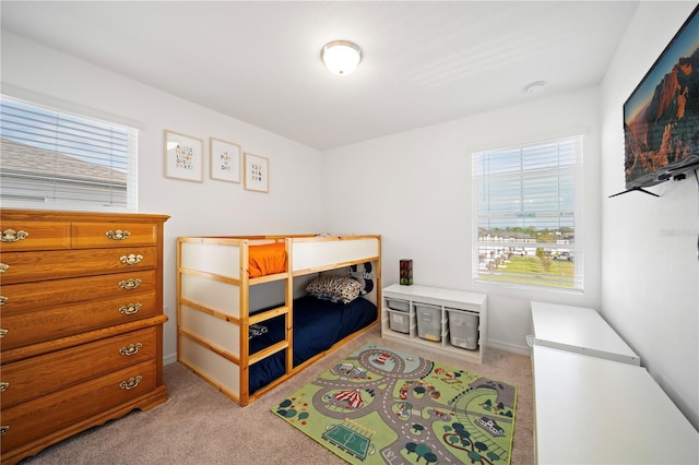 carpeted bedroom featuring multiple windows