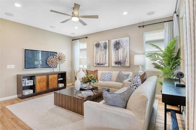 living room featuring light hardwood / wood-style flooring and ceiling fan