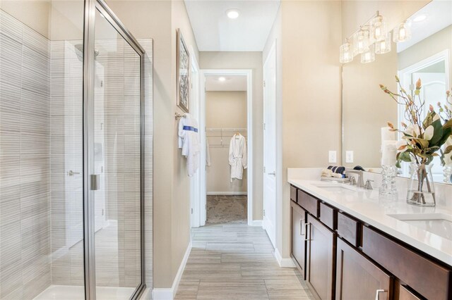 bathroom featuring vanity, hardwood / wood-style flooring, and a shower with door