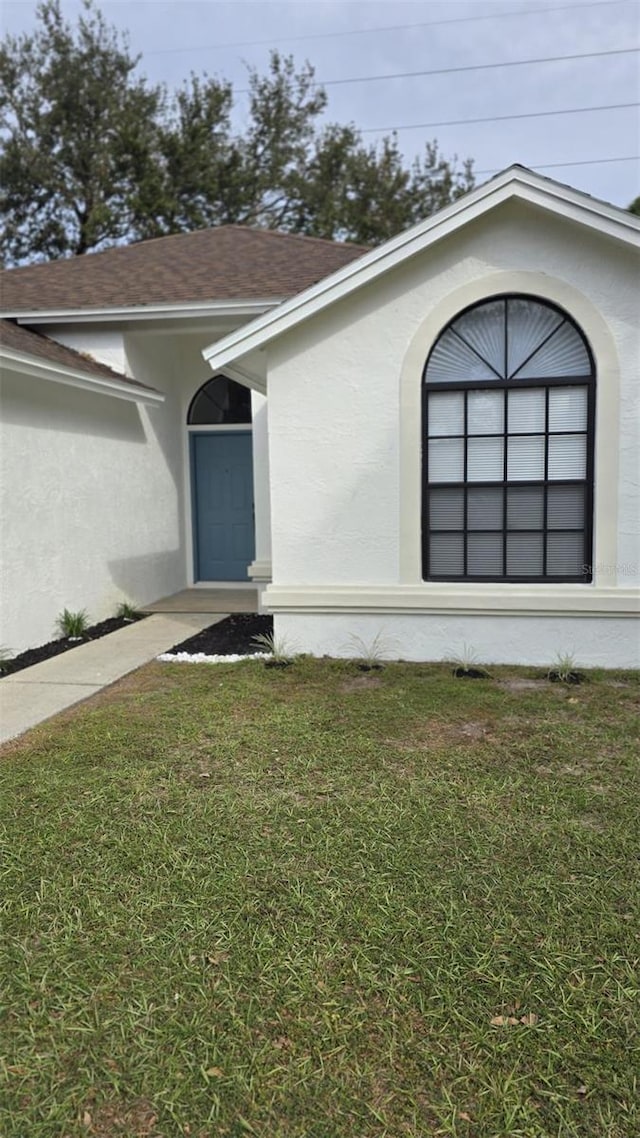 property entrance featuring a lawn