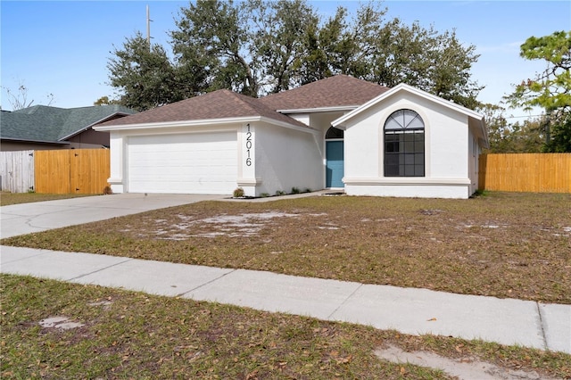 ranch-style home with a garage and a front lawn