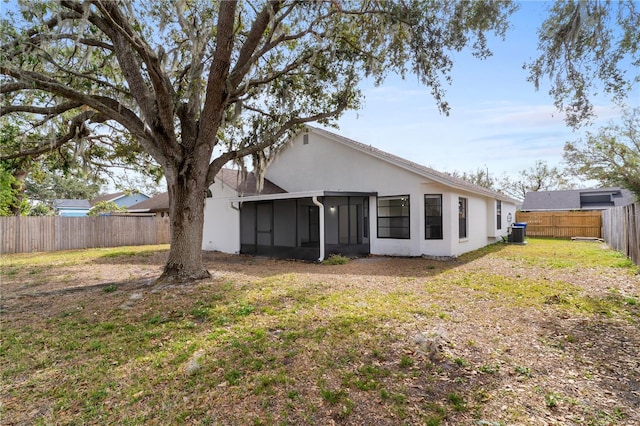 back of property with cooling unit, a yard, and a sunroom