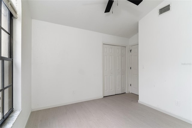 spare room with ceiling fan, lofted ceiling, and light wood-type flooring