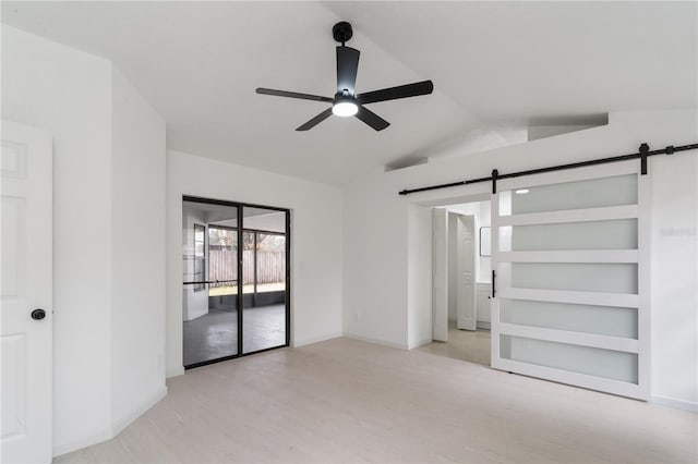 unfurnished bedroom with vaulted ceiling, light hardwood / wood-style flooring, access to outside, ceiling fan, and a barn door