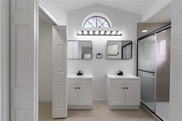 bathroom featuring vanity, vaulted ceiling, and walk in shower