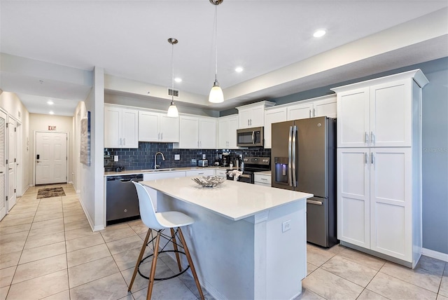 kitchen with white cabinetry, appliances with stainless steel finishes, sink, and hanging light fixtures