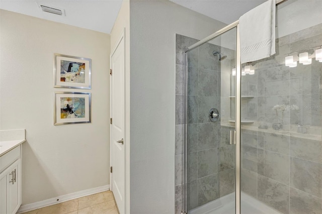 bathroom with vanity, a shower with shower door, and tile patterned floors