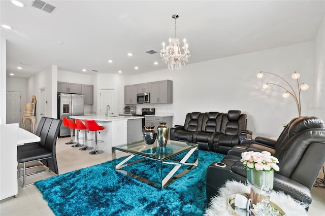 living room with light tile patterned floors, an inviting chandelier, and sink