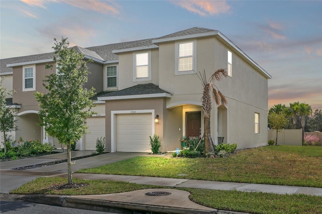 view of front of home with a garage and a lawn