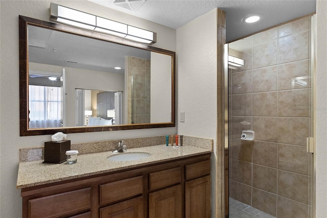 bathroom with vanity, a textured ceiling, and walk in shower