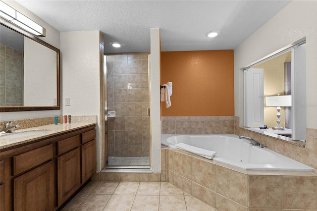 bathroom featuring vanity, a textured ceiling, plus walk in shower, and tile patterned flooring