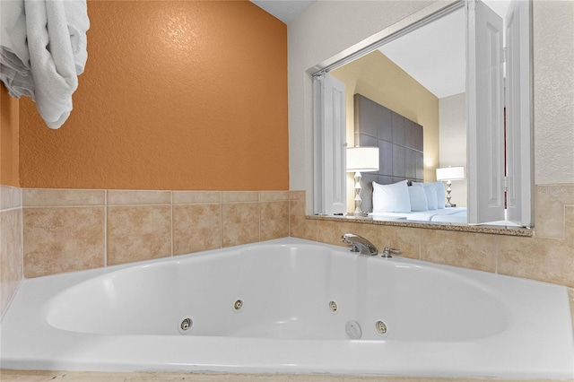 12527 Floridays Resort Dr Unit E-103, Orlando, FL 32821 - full bath featuring a textured wall and a tub with jets
