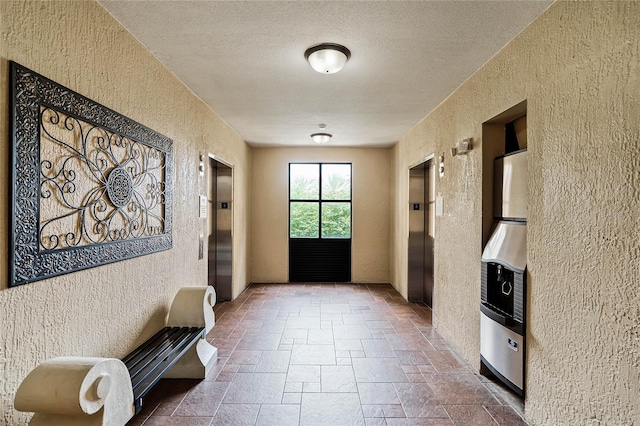12527 Floridays Resort Dr Unit E-103, Orlando, FL 32821 - hallway featuring a textured wall, stone tile floors, elevator, and a textured ceiling