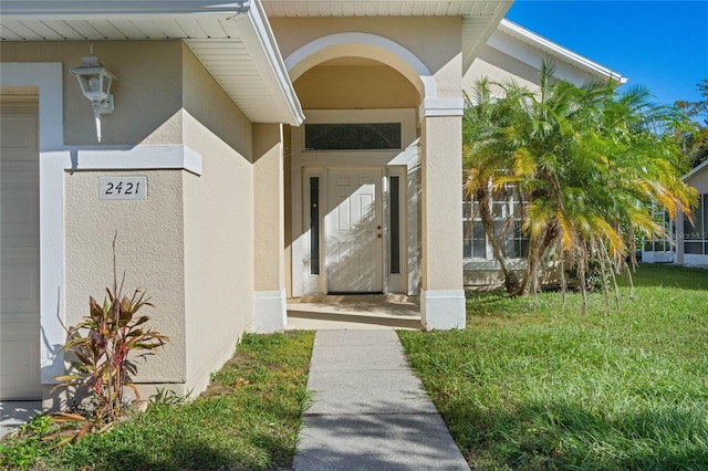 property entrance featuring a lawn