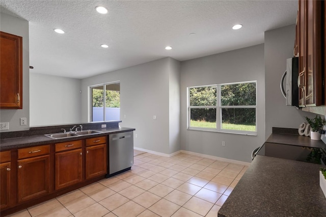 kitchen with sink, appliances with stainless steel finishes, a textured ceiling, and light tile patterned floors