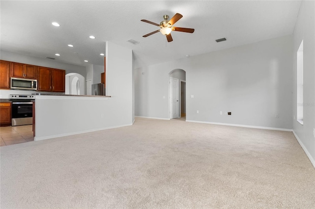 unfurnished living room with light carpet and ceiling fan