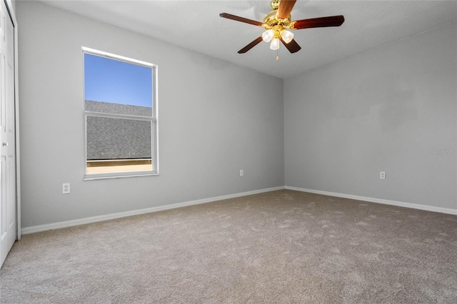 carpeted spare room featuring ceiling fan