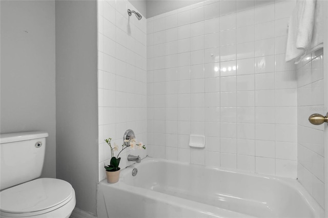 bathroom featuring toilet and tiled shower / bath combo