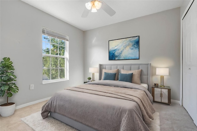 bedroom with a closet, light colored carpet, and ceiling fan