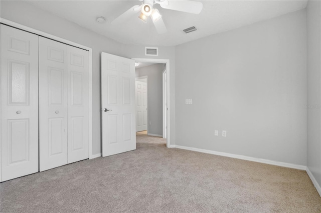 unfurnished bedroom featuring a closet, light colored carpet, and ceiling fan