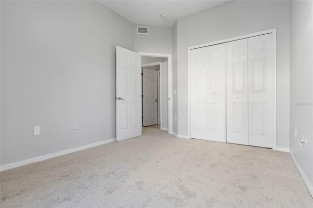 unfurnished bedroom with a closet and light carpet