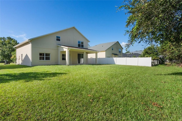 back of house with a lawn