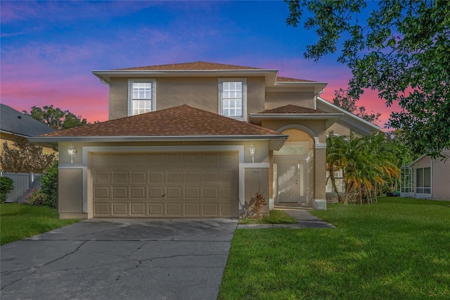 view of front of house featuring a garage and a lawn